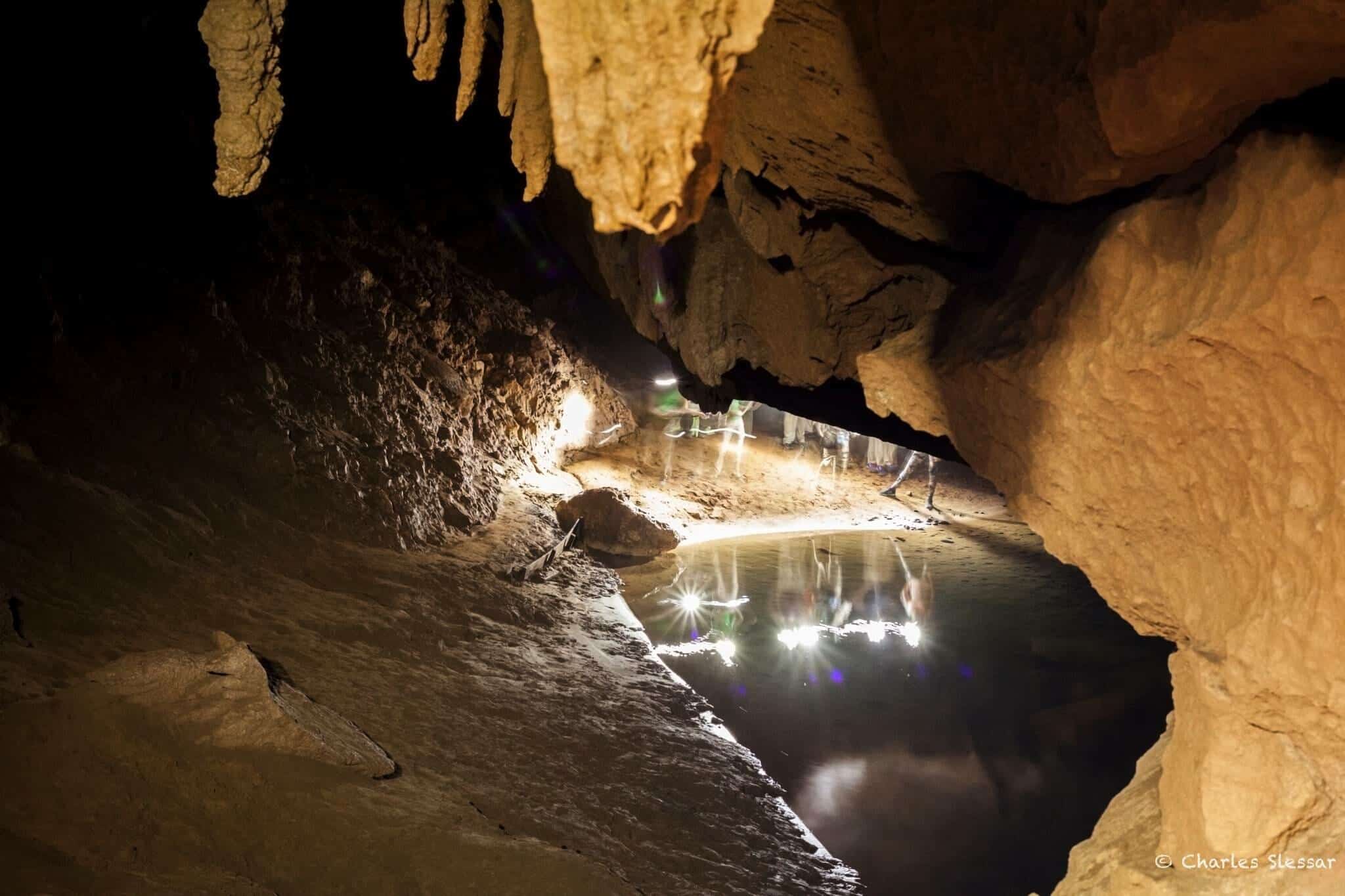 Headlamps reflected in pool in St Herman's cave in Belize